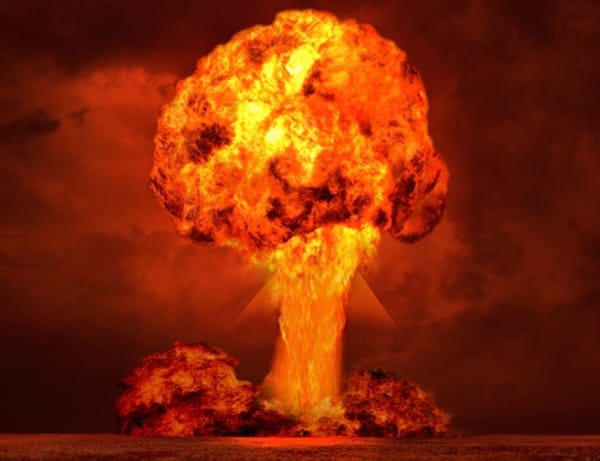 A large orange and yellow mushroom cloud rises into a dark sky, indicating an explosion.